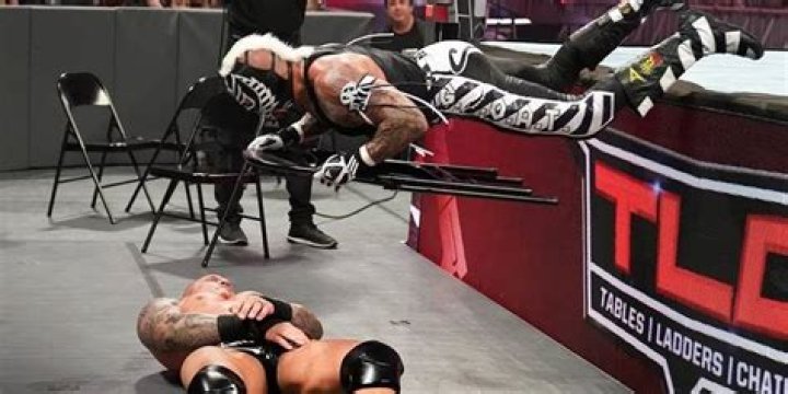 Rey Mysterio slides out of the ring with a chair 